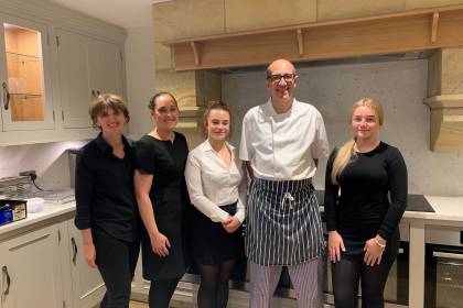 Chef and waiting staff in kitchen