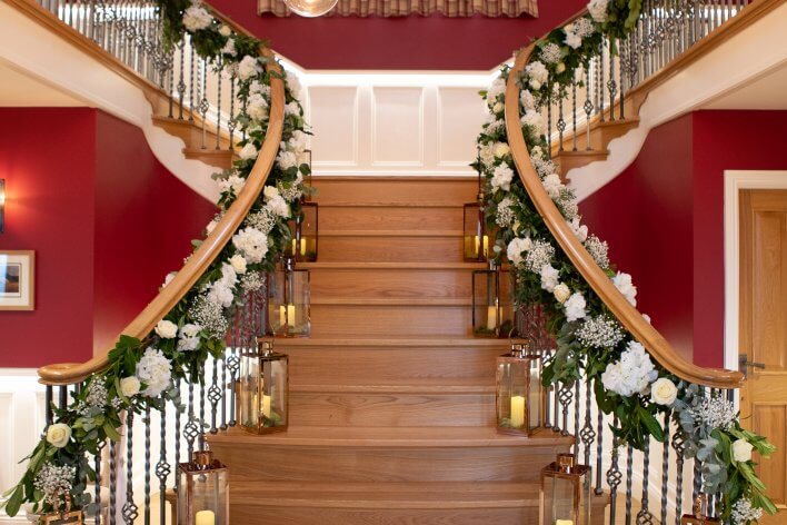 flower garland fixed to staircase with lanterns on steps