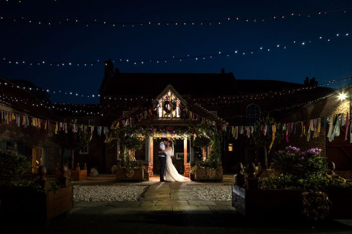 Wedding couple outdoors at night with fairy lights