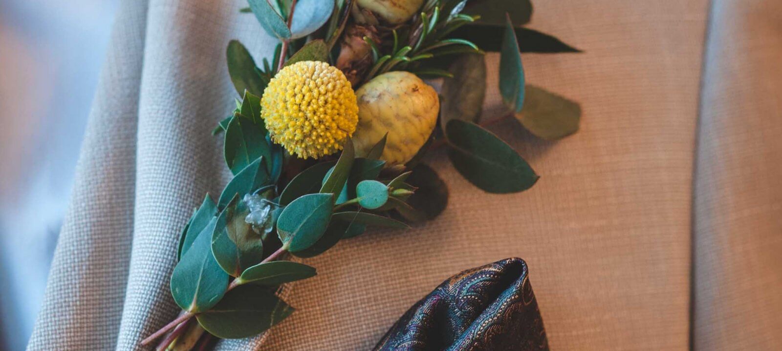 Close up shot of suit with foliage buttonhole and pocket square