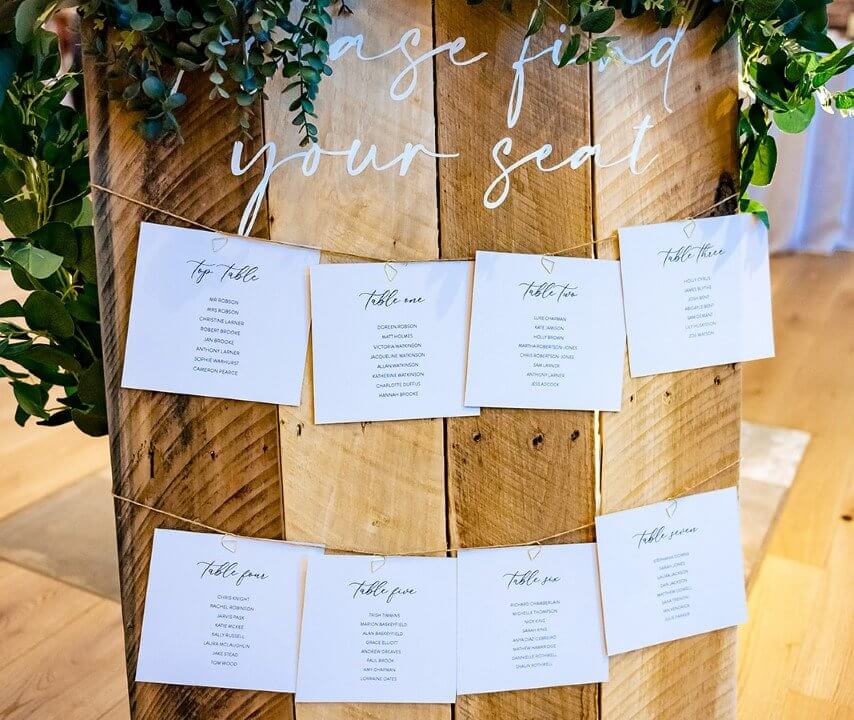 wooden board with table seating plans attached to it