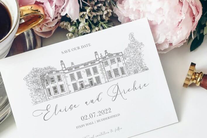 Save our date card propped against bunch of flowers