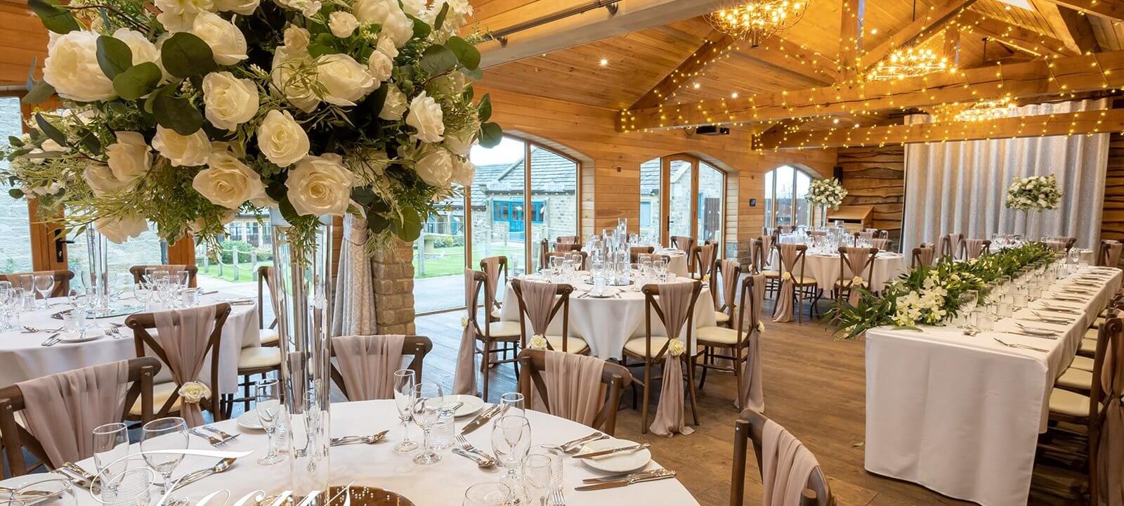 Wedding celebration room with dining tables and flower arrangements